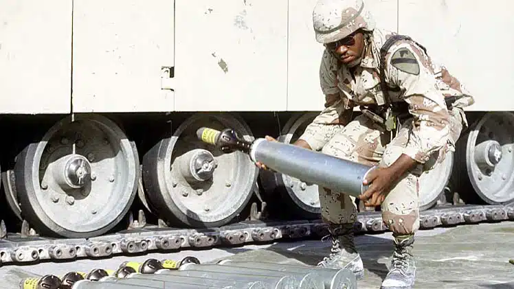 A US soldier carries a an armor-piercing munition tipped with depleted uranium during "Operation Desert Shield", the US military operation agains Iraq in 1991. (Department of Defense)